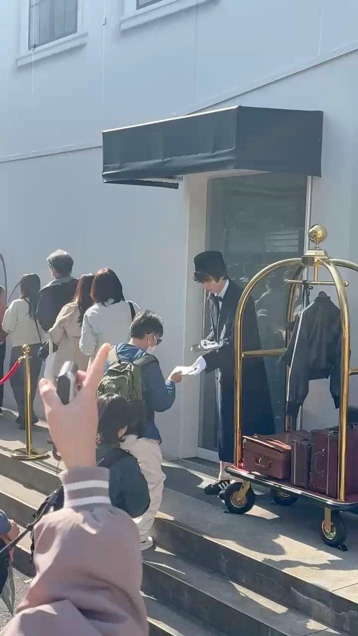 A costumed bellhop hands out promotional materials at the Adidas Superstar hotel-themed pop-up in Harajuku, Tokyo